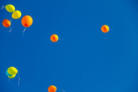 Colorful balloons flying in the blue skyの写真素材