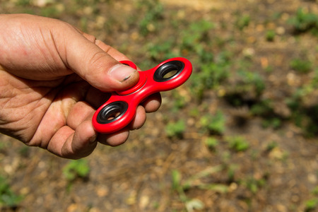 Man playing with fidget spinner stress relieving toy outdoorの写真素材