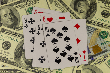 Playing cards on the American one hundred dollar bills background. Game concept