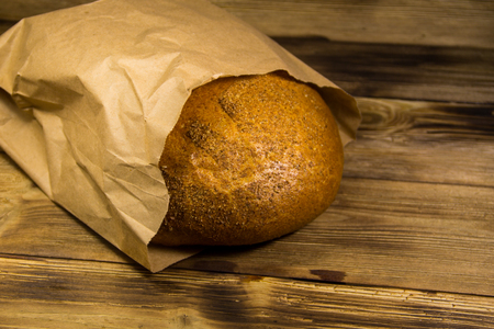 Bread packed in paper on wooden tableの写真素材