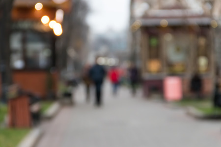 Blurred abstract background. Unrecognizable silhouettes of people walking on city streetの写真素材