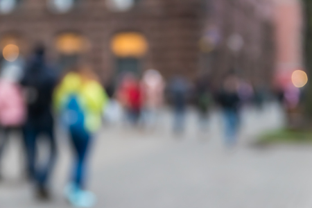 Blurred abstract background. Unrecognizable silhouettes of people walking on city streetの写真素材