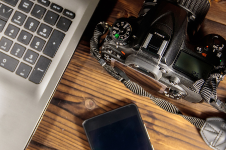 Laptop, smart phone and photo camera on wooden backgroundの写真素材