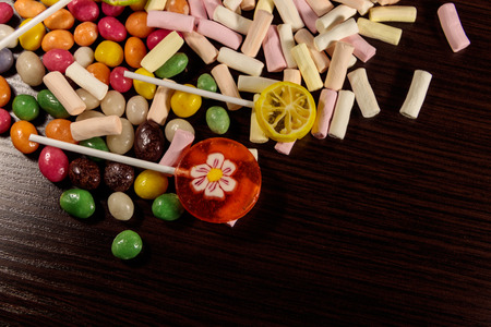 Colorful candies, lollipops and marshmallows on wooden tableの写真素材