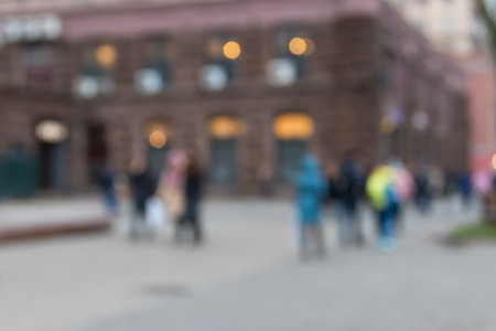 Blurred abstract background. Unrecognizable silhouettes of people walking on city streetの写真素材