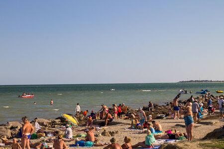 Genichesk, Ukraine - August 25, 2017: Unknown people enjoy on the beach of Azov seaのeditorial素材