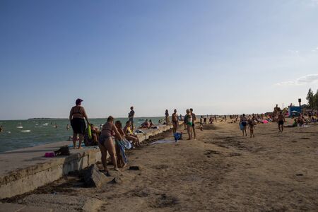 Genichesk, Ukraine - August 25, 2017: Unknown people enjoy on the beach of Azov seaのeditorial素材