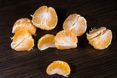Lobules of mandarin on dark wooden tableの写真素材