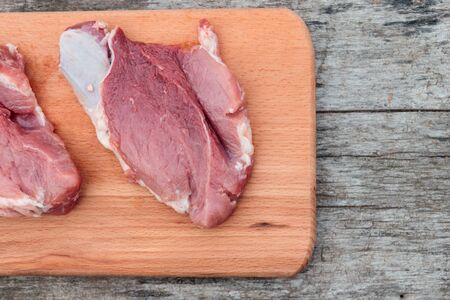 Raw pork meat on cutting board on rustic  table. Top viewの写真素材