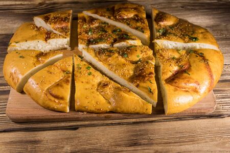 Sliced pita bread on cutting board on wooden table