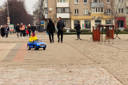 Kremenchug, Ukraine - January 6, 2018: Little boy driving toy car in city park. Kids leisureのeditorial素材