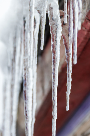 Icicles hanging from roofの写真素材