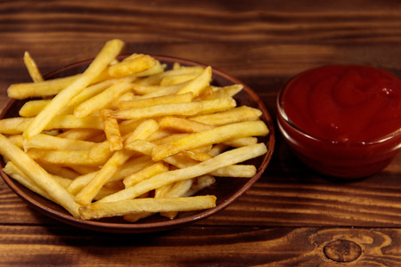 French fries with ketchup on wooden tableの写真素材