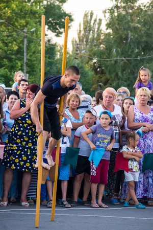 Genichesk, Ukraine - August 26, 2017: Men compete in walking on wooden stilts during festival Tavriyska rodyna (Tavria Family)のeditorial素材