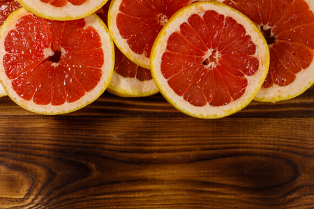 Sliced grapefruits on wooden table. Top view, copy spaceの写真素材