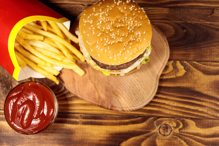 Delicious big hamburger with french fries and ketchup on wooden table. Top viewの写真素材