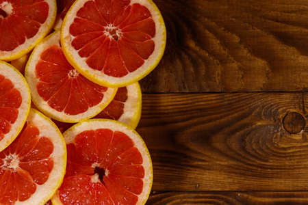Sliced grapefruits on wooden table. Top view, copy spaceの写真素材