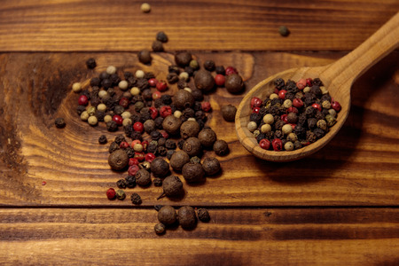 Mix of peppercorn in wooden spoon on a tableの写真素材
