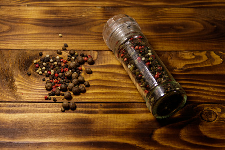 Glass pepper shaker with mix of peppercorn on wooden backgroundの写真素材