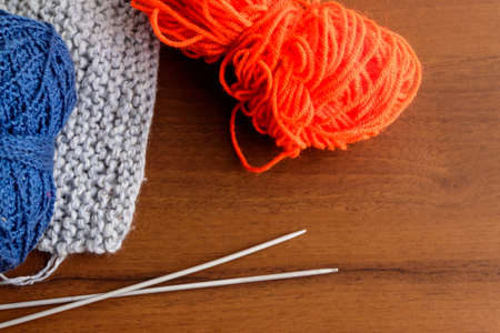 Woolen thread, knitting, knitting needles on wooden tableの写真素材