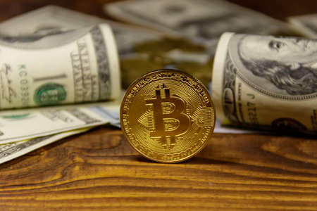Golden bitcoin and dollars on wooden backgroundの写真素材