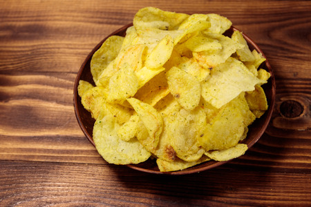 Plate of potato chips on wooden tableの写真素材