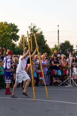 Genichesk, Ukraine - August 26, 2017: Men compete in walking on wooden stilts during festival Tavriyska rodyna (Tavria Family)のeditorial素材