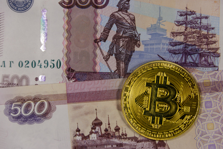 Golden bitcoin on five hundred russian rubles bills backgroundの写真素材