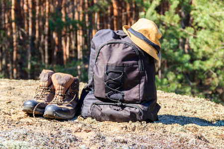 Tourist backpack, hiking boots and hat on the glade in pine forest. Hike conceptの写真素材