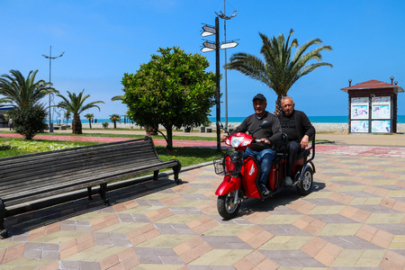 Batumi, Adjara, Georgia - May 3, 2018: Unknown people riding a moped on the Batumi boulevardのeditorial素材
