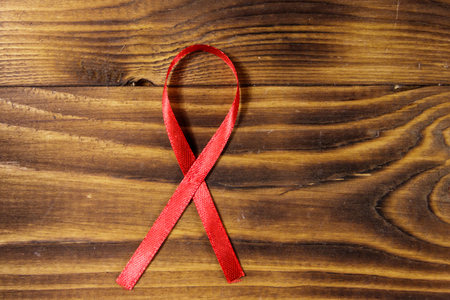 Red AIDS ribbon on wooden backgroundの写真素材