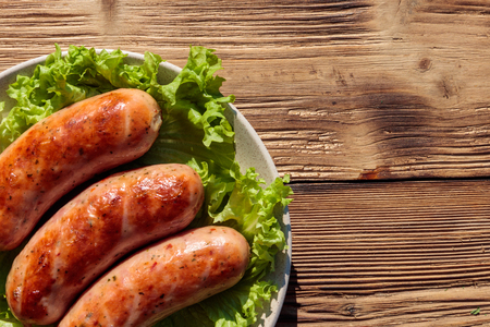 Grilled sausages on wooden table. Top viewの写真素材