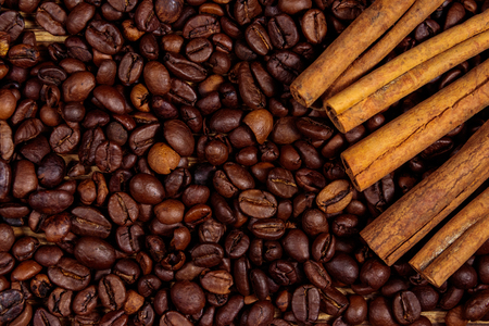 Roasted coffee beans and cinnamon sticks on rustic wooden background. Top viewの写真素材