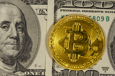 Golden bitcoin on hundred dollar bills background Golden bitcoin on hundred dollar bills background
