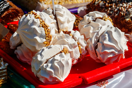 Round meringue cookies filling with condensed milk and nuts on a trayの写真素材