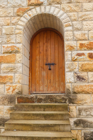 Closed wooden door on stone wallの写真素材
