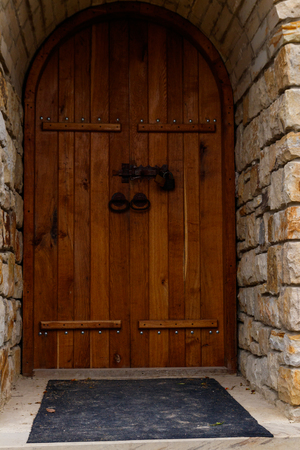 Closed wooden door on stone wallの写真素材