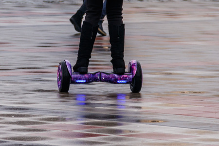 Legs of girl riding on self-balancing mini hoverboard in the city street.の写真素材