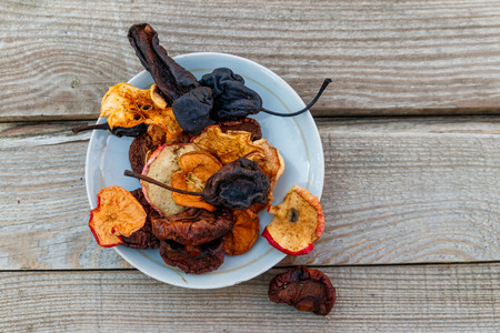 Mix of dried fruits in a plate on wooden table. Top viewの写真素材