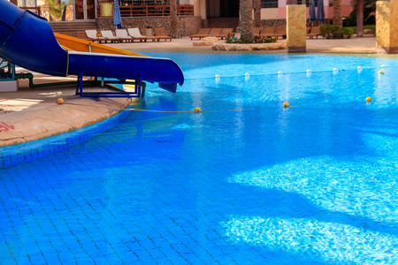 Swimming pool with water slide at the tropic summer resort