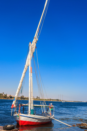 Felucca boat moored near the shore of Nile river in Luxor, Egyptの写真素材