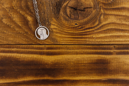 Virgin Mary pendant on wooden background. Top view, copy spaceの写真素材