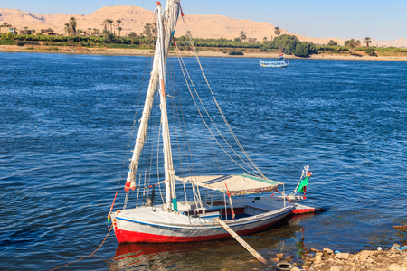 Felucca boat moored near the shore of Nile river in Luxor, Egyptの写真素材