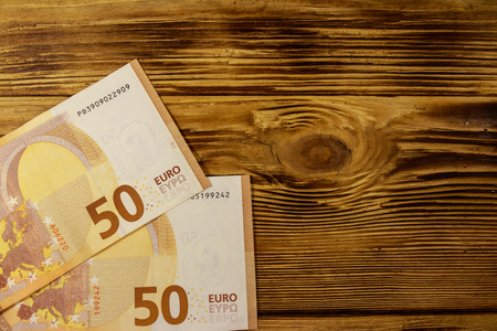 Fifty euro banknotes on wooden background. Top view, copy space