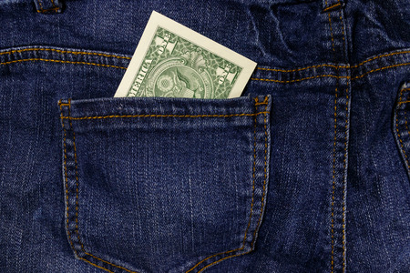 One dollar bill in a pocket of blue jeansの写真素材