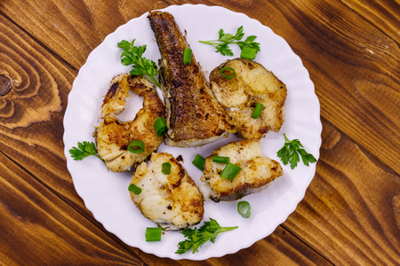 Roasted pollock in white plate on a wooden tableの写真素材