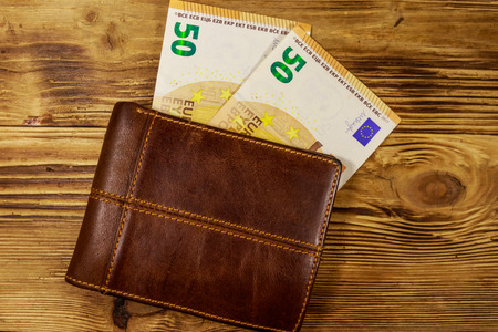 Wallet and fifty euro banknotes on wooden backgroundの写真素材
