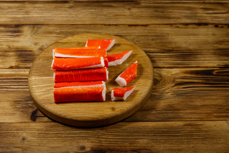 Crab sticks on cutting board on wooden tableの写真素材
