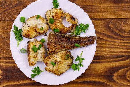 Roasted pollock in white plate on a wooden tableの写真素材