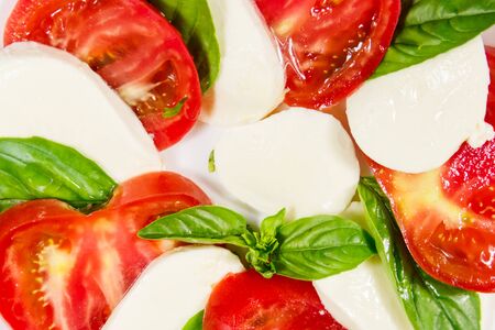 Italian caprese salad with tomatoes, mozzarella cheese and basil. Close-upの写真素材